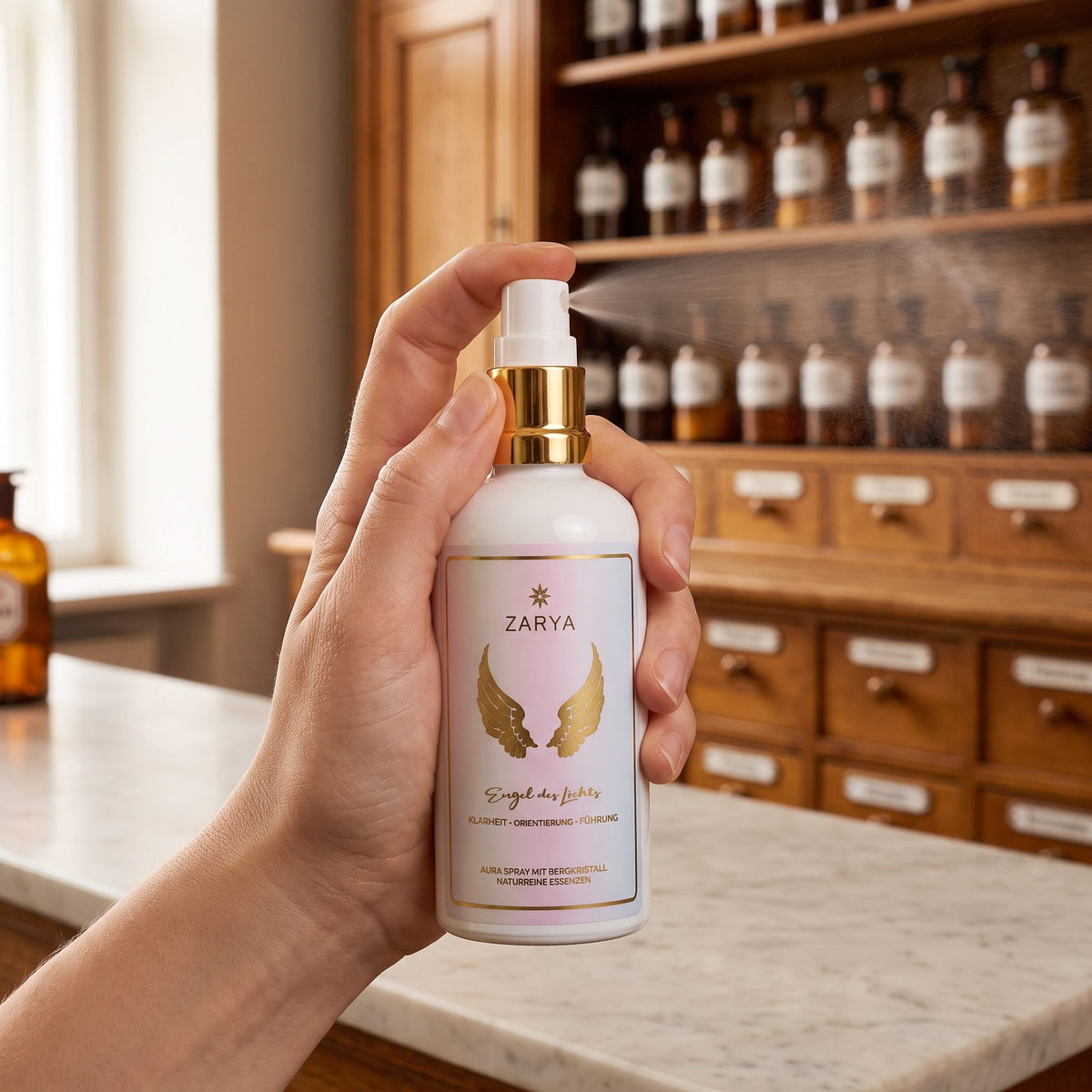 Eine Hand sprüht das Aura Spray Engel des Lichts fein in den Raum