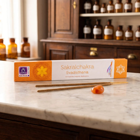 Sakralchakra Räucherstäbchen Holy Smokes: Packung auf einer Marmortheke vor einem Apothekerschrank, daneben zwei lose Räucherstäbchen und ein Karneol – Spirit of Gaia