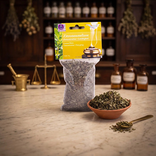 Zitronenmelisse, sortenreines Räucherwerk von Berk, 10 g: Packung auf der Marmortheke einer alten Apotheke am Abend, daneben eine Terracottaschale mit getrockneter Zitronenmelisse und ein Messinglöffel – Spirit of Gaia
