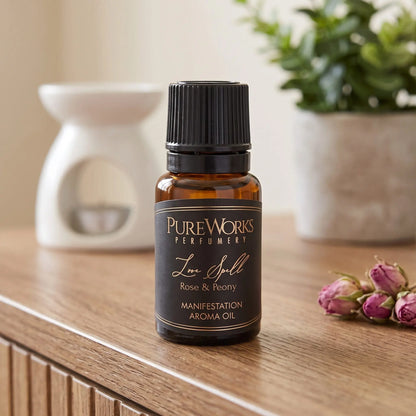 Aromaöl Love Spell (Rose & Pfingstrose): Fläschchen auf einem Holz-Sideboard im Wohnzimmer, im Hintergrund eine weiße Duftlampe, daneben getrocknete Rosenknospen