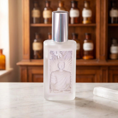 SeelenTor Weiße Essenz: Sprühflakon aus satiniertem Glas mit Bildetikett auf Marmortheke vor Apothekerschrank, daneben ein Selenit – Spirit of Gaia