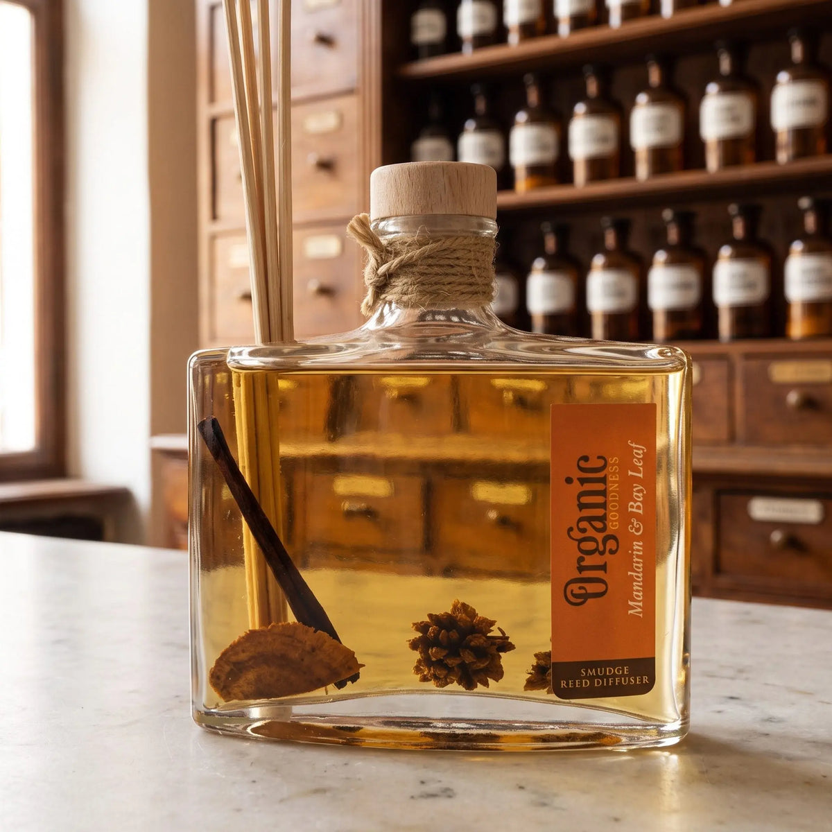 Flaschenhals des Reed Diffusers Mandarine und Lorbeerblatt aus der Nähe: Holzstopfen, Jutekordel, Schilfrohrstäbchen und das Holz und die Blütenköpfe im Öl