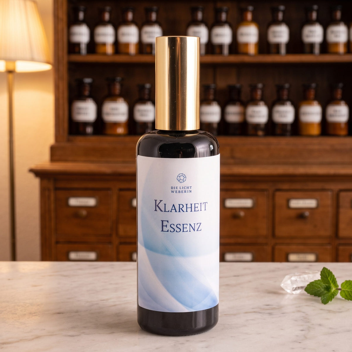 Klarheit Aura Spray der Lichtweberin, dunkle Flasche mit goldener Kappe auf einer Apothekentheke