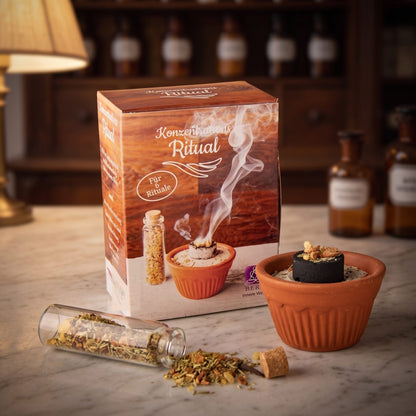 Konzentrationsritual von Berk: Schachtel, Tontöpfchen mit Kohletablette und Glasröhrchen mit Räuchermischung auf der Marmortheke einer Apotheke am Abend