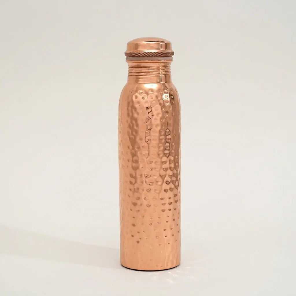 Gehämmerte Kupfer-Trinkflasche Ayurveda freigestellt auf hellem Hintergrund mit Schatten