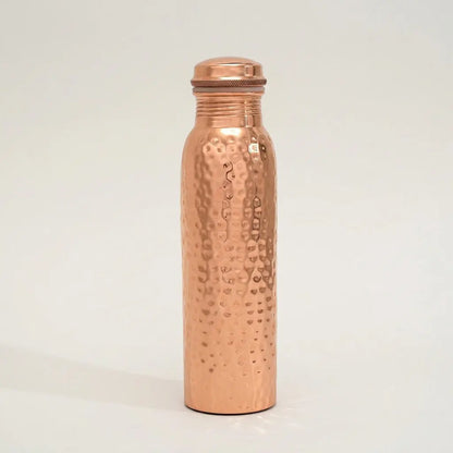 Gehämmerte Kupfer-Trinkflasche Ayurveda freigestellt auf hellem Hintergrund mit Schatten