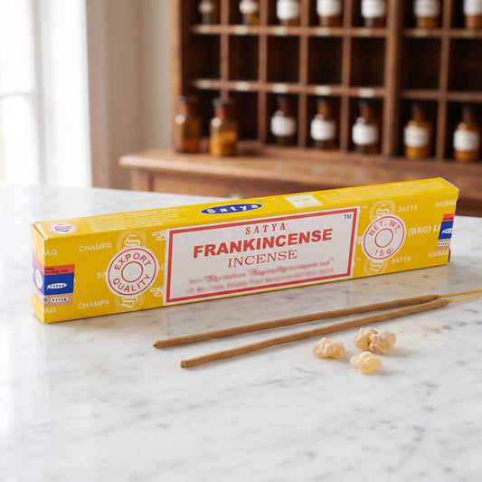 Satya Frankincense Räucherstäbchen: 15-g-Packung auf einer Marmortheke vor einem Apothekerschrank, daneben zwei lose Räucherstäbchen – Spirit of Gaia