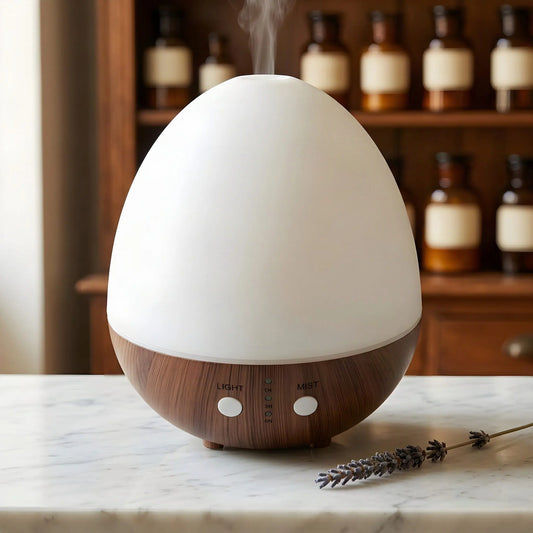 Aroma Diffuser Oval Weiß mit mattweißer Haube und Sockel in dunkler Holzoptik, feiner Nebel, vor Apothekerschrank – Spirit of Gaia