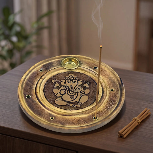 Räucherstäbchen/Weihrauchkegelhalter Ganesha in Benutzung mit feinem Rauch auf einem dunklen Holz-Sideboard am Abend