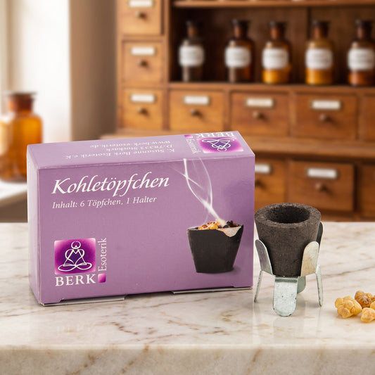 Kohletöpfchen mit Halter auf einer Marmortheke vor einem Apothekerschrank – Spirit of Gaia