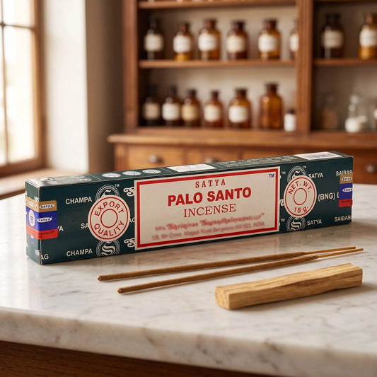 Satya Palo Santo Räucherstäbchen: 15-g-Packung auf einer Marmortheke vor einem Apothekerschrank, daneben zwei lose Räucherstäbchen – Spirit of Gaia