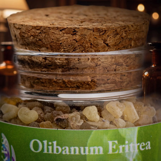Olibanum Eritrea, reiner Weihrauch von Berk, 60 ml im Korkglas: Nahaufnahme des Glases mit Weihrauchharz, Korken und Etikett vor der warmen, unscharfen Abendapotheke – Spirit of Gaia