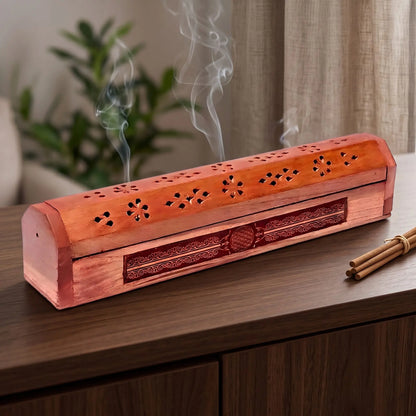Räucherkistchen Blume des Lebens in Benutzung mit feinem Rauch auf einem dunklen Holz-Sideboard am Abend