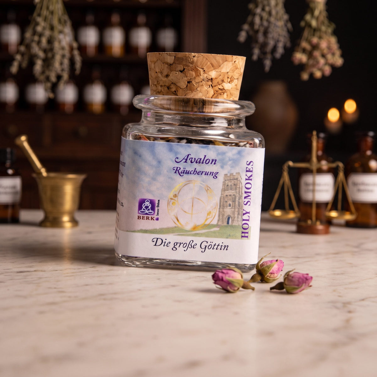 Die große Göttin, Avalon-Räuchermischung von Berk, 50 ml im Korkglas: Korkglas auf der Marmortheke einer alten Apotheke am Abend, daneben drei getrocknete Rosenknospen – Spirit of Gaia