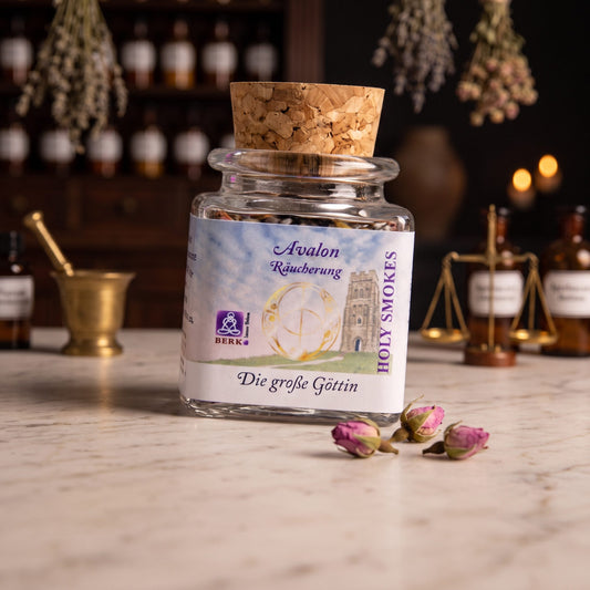 Die große Göttin, Avalon-Räuchermischung von Berk, 50 ml im Korkglas: Korkglas auf der Marmortheke einer alten Apotheke am Abend, daneben drei getrocknete Rosenknospen – Spirit of Gaia