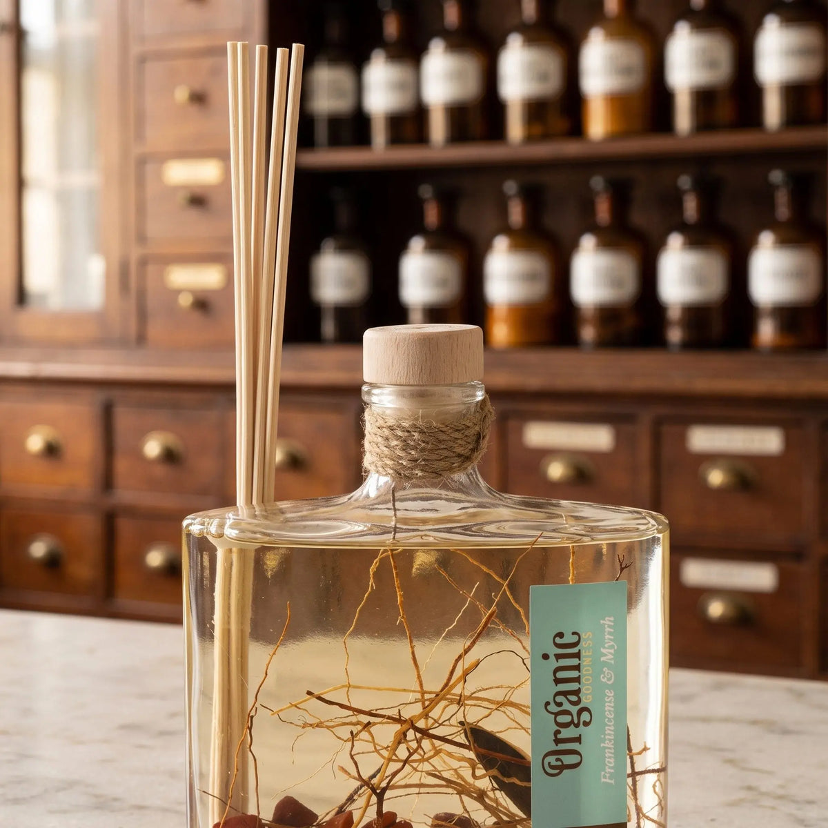 Flaschenhals des Reed Diffusers Weihrauch und Myrrhe aus der Nähe: Holzstopfen, Jutekordel, Schilfrohrstäbchen und die Zweige und Harzstücke im Öl