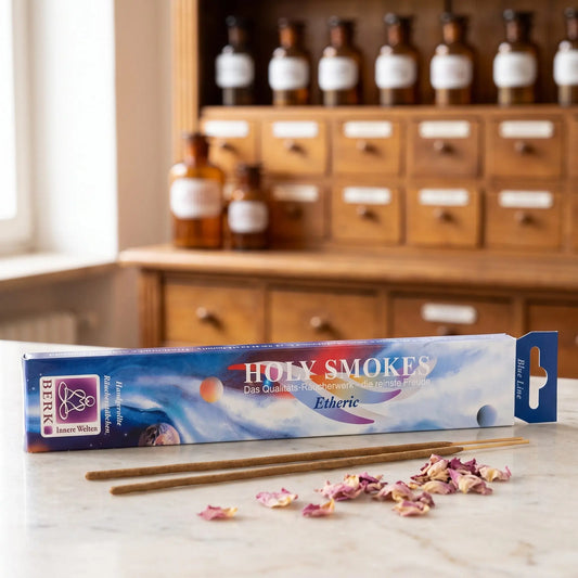 Etheric Räucherstäbchen Blue Line: Packung auf einer Marmortheke vor einem Apothekerschrank, daneben zwei lose Räucherstäbchen und ein paar getrocknete rosa Rosenblätter – Spirit of Gaia