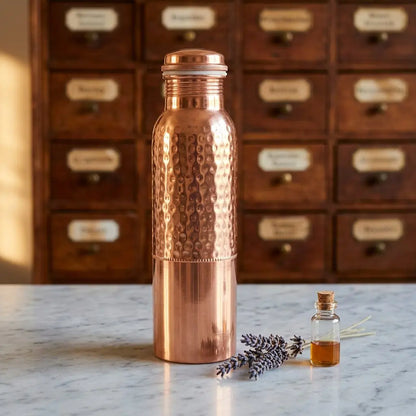 Kupfer-Trinkflasche mit Punkt-Hammerschlag auf Marmortheke vor Apothekerschrank – Spirit of Gaia