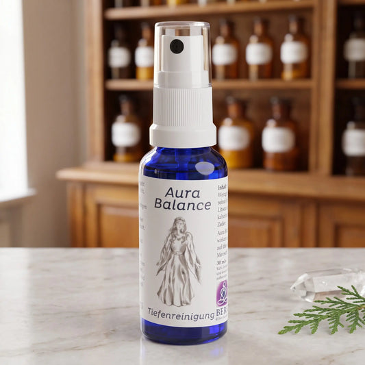 Energiespray Tiefenreinigung (Aura Balance): blaue Sprühflasche mit weißem Etikett auf Marmortheke vor Apothekerschrank, daneben ein Bergkristall und ein Zedernzweig – Spirit of Gaia