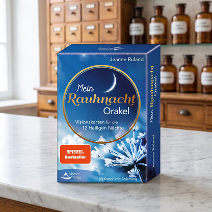 Kartenset Mein Rauhnacht-Orakel von Jeanne Ruland in blauer Schachtel steht auf der Marmortheke einer hellen Apotheke