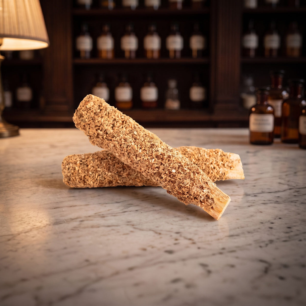 Palo Santo mit Eukalyptus von Berk: zwei mit Kräutern überzogene Holzstäbe liegen gekreuzt auf der Marmortheke einer Apotheke am Abend