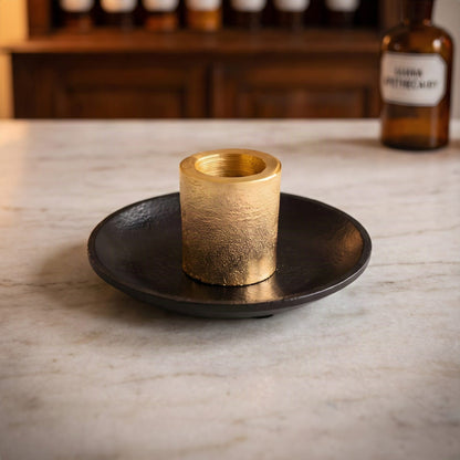 Palo Santo Halter mit schwarzem Teller und goldener Hülse auf der Marmortheke einer Apotheke am Abend
