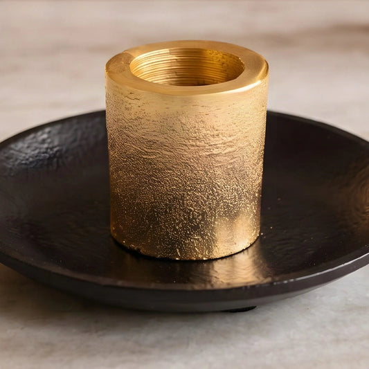 Nahaufnahme der goldenen Hülse mit körniger Oberfläche auf dem schwarzen Teller