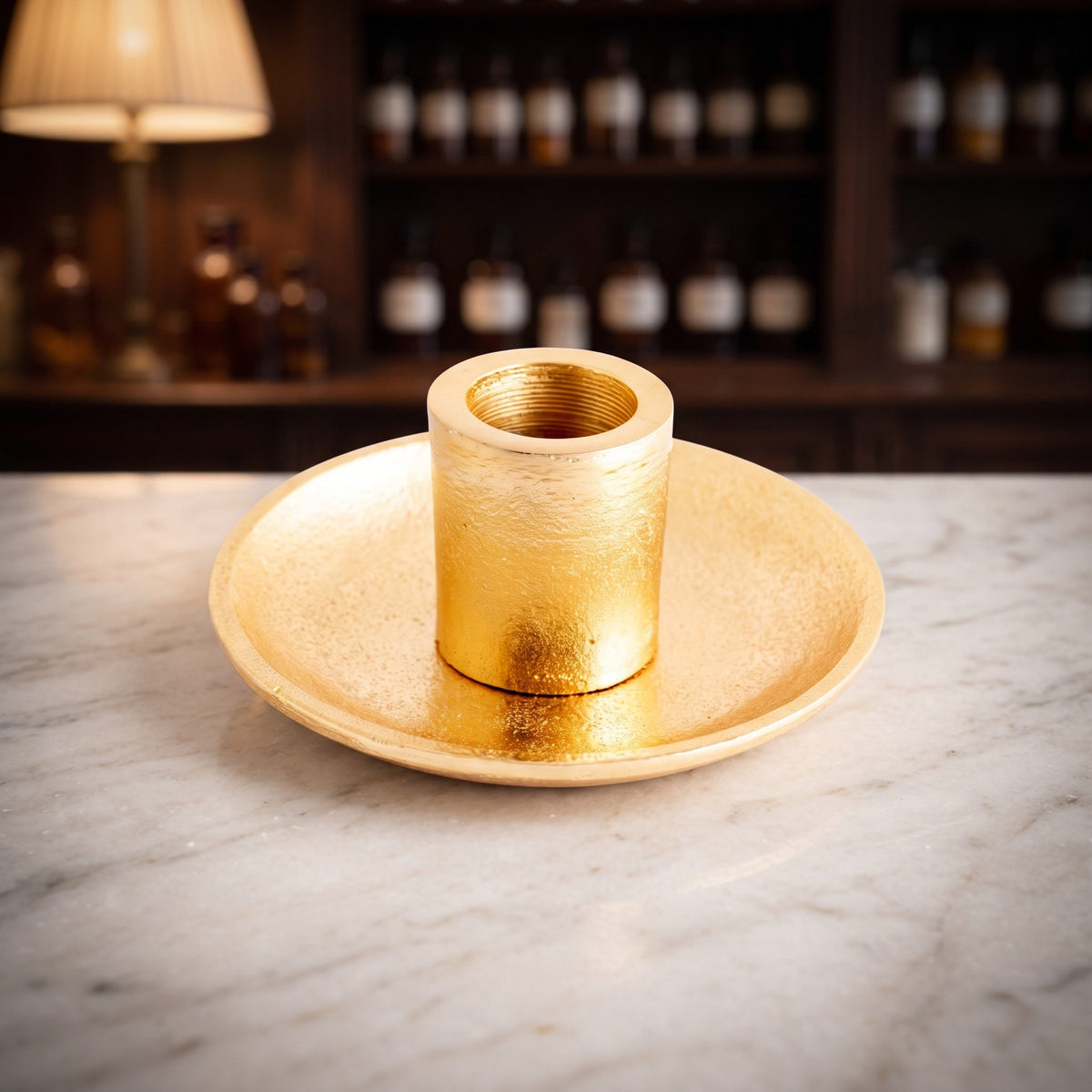 Palo Santo Halter aus goldfarbenem Weißmetall, Teller mit Hülse, auf der Marmortheke einer Apotheke am Abend