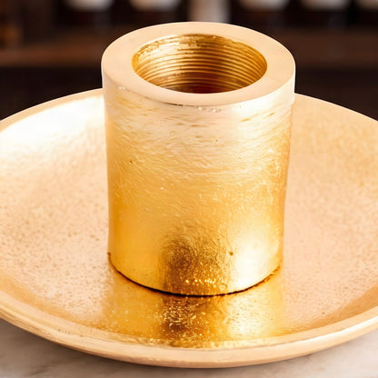 Nahaufnahme der goldenen Hülse mit rauer Oberfläche und fein gerilltem Inneren auf dem goldenen Teller