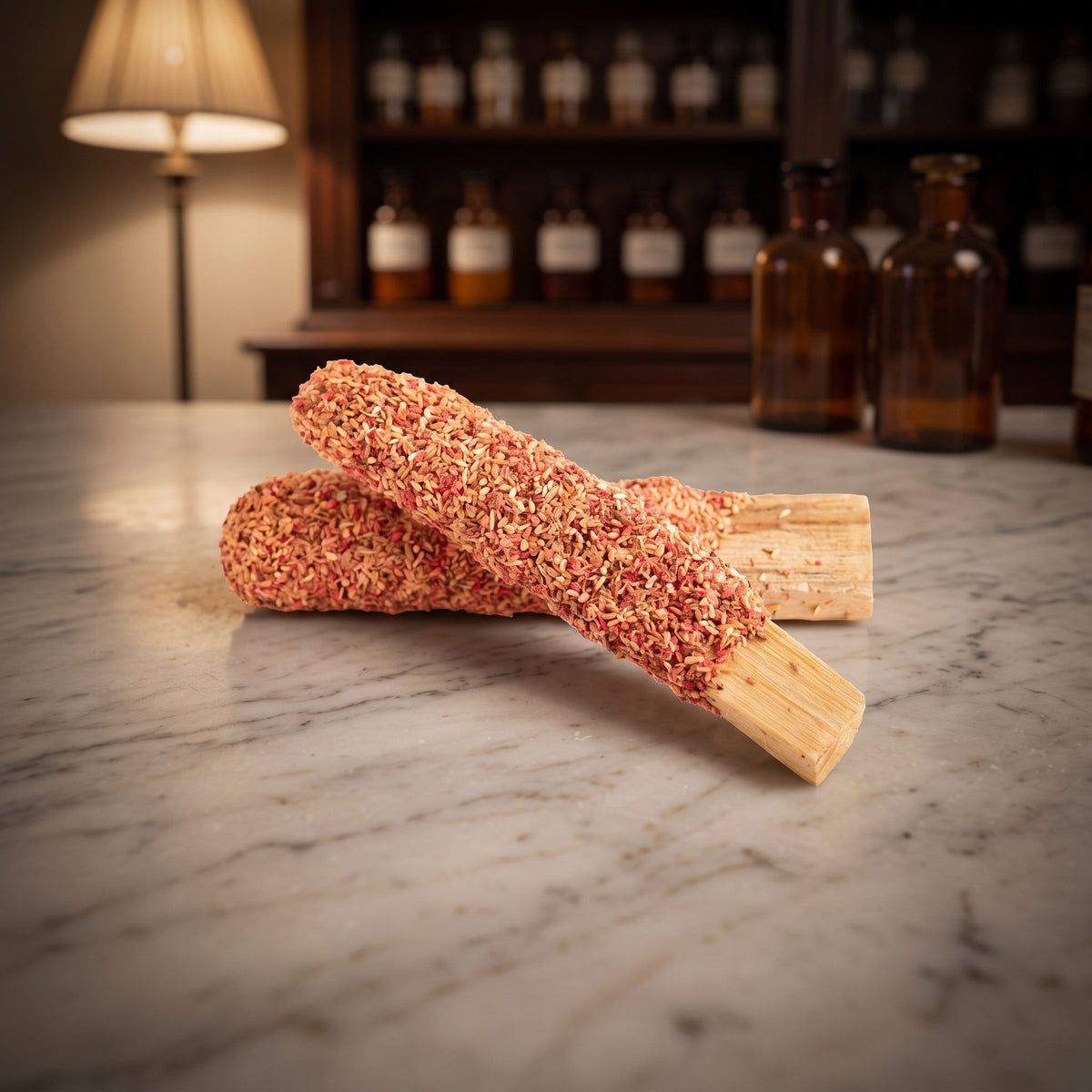 Palo Santo mit Rose von Berk: zwei mit Rosenblüten überzogene Holzstäbe liegen gekreuzt auf der Marmortheke einer Apotheke am Abend