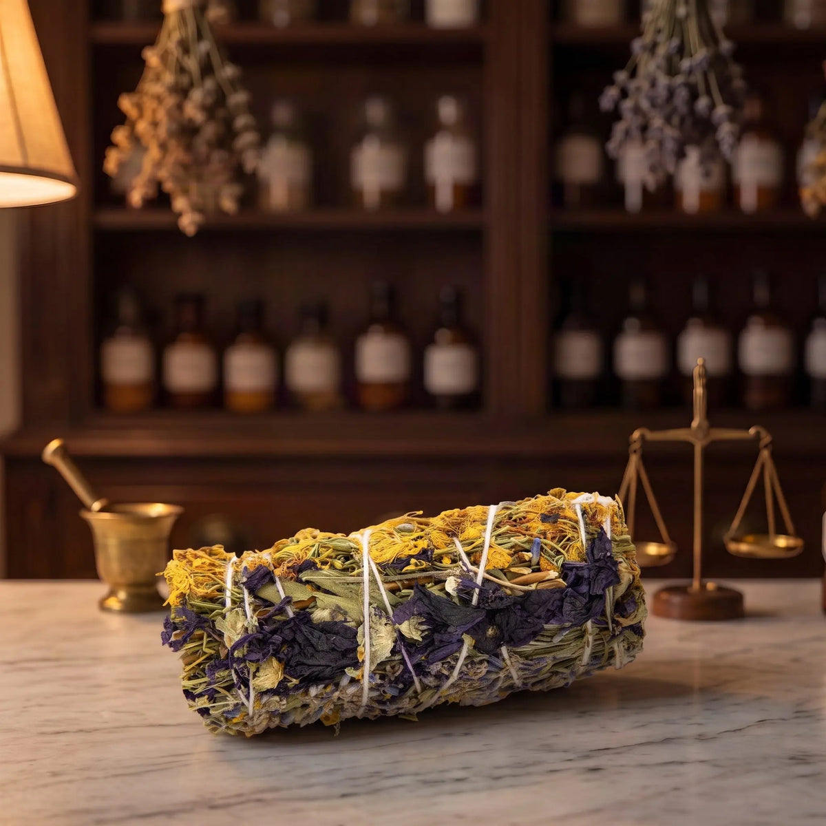 Premium-Räucherbündel Innere Ruhe von Berk liegt auf der Marmortheke einer Apotheke am Abend, Johanniskraut, Malve und Lavendel mit hellem Garn