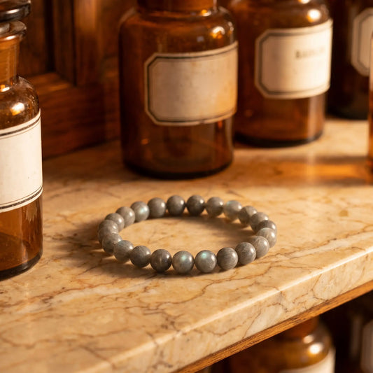 Labradorit Armband – graues Edelstein-Kugelarmband (8 mm) mit blau-grünem Schiller auf Marmorablage