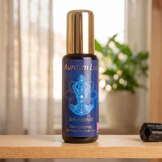Energiespray Aureum Lux Schutzschild: Sprühflasche auf einem hellen Holzregal am Fenster mit Leinenvorhang, daneben ein schwarzer Turmalin