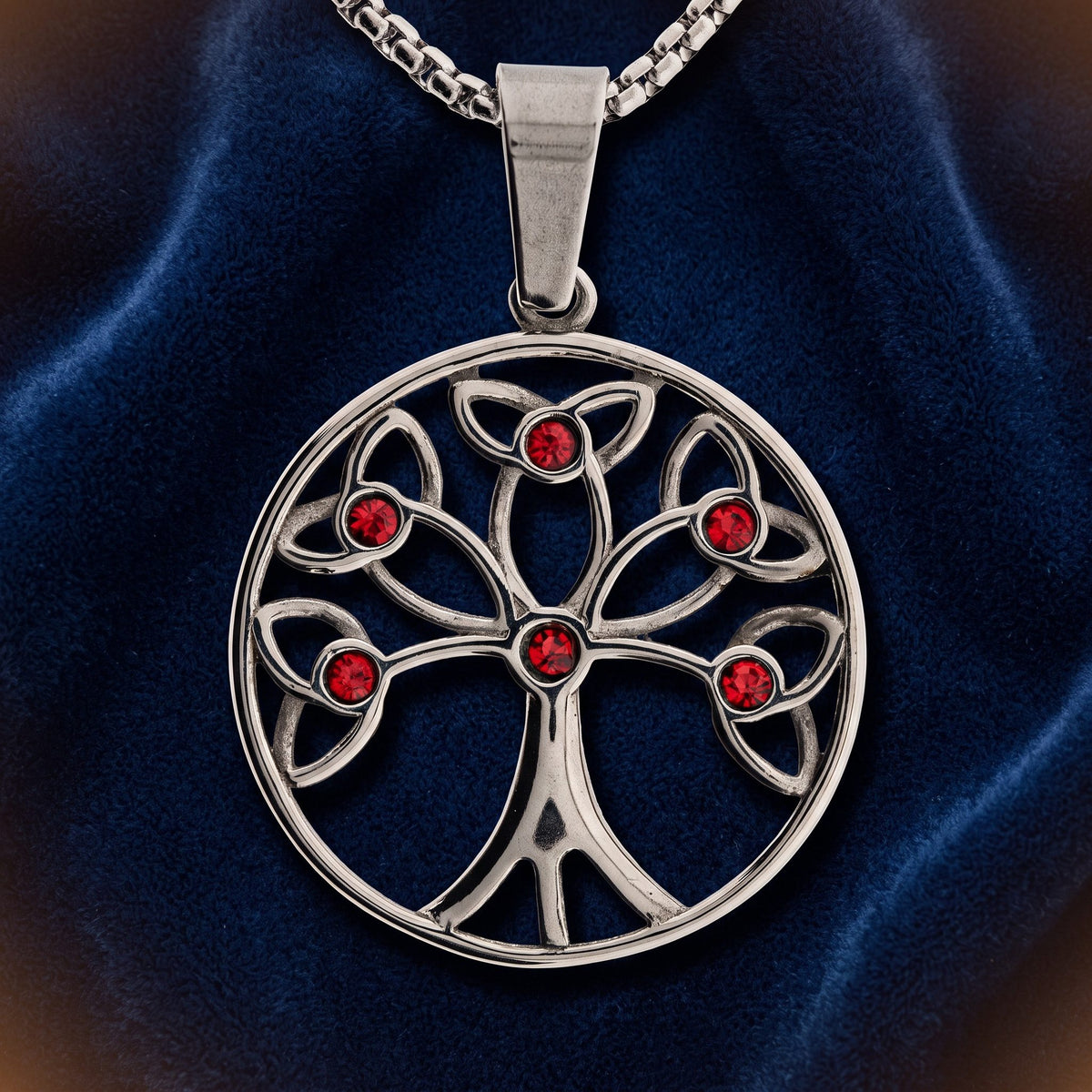 Yggdrasil Anhänger aus Edelstahl mit sechs roten Glassteinchen, an Kette auf dunkelblauem Samt