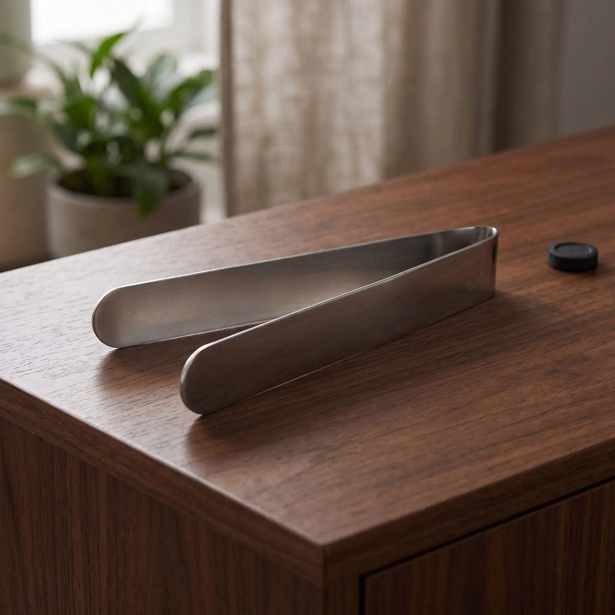 Räucherzange auf einem dunklen Holz-Sideboard im Wohnzimmer