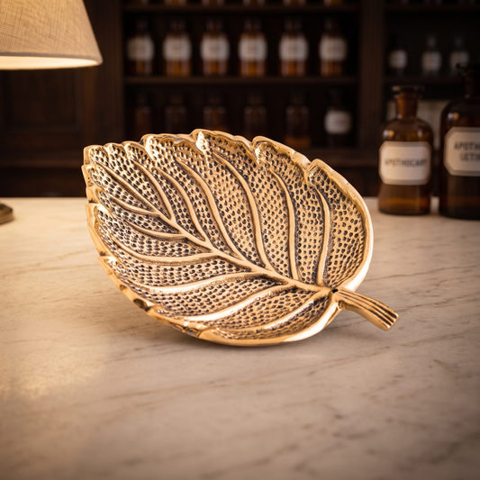 Räucherstäbchenhalter Blatt aus bronze platiniertem Weißmetall mit Punktmuster auf der Marmortheke einer Apotheke am Abend