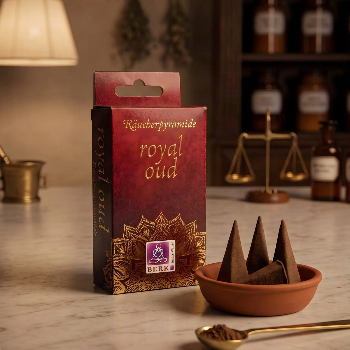 Royal Oud Räucherpyramiden von Berk: rote Schachtel mit Goldschrift auf der Marmortheke einer Apotheke am Abend, daneben eine Schale mit Kegeln