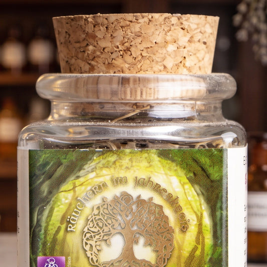 Imbolc, Jahreskreisfeste-Räuchermischung von Berk, 50 ml im Korkglas: Nahaufnahme von Korken, Glashals und Etikett mit dem Lebensbaum-Motiv vor der warmen, unscharfen Abendapotheke – Spirit of Gaia