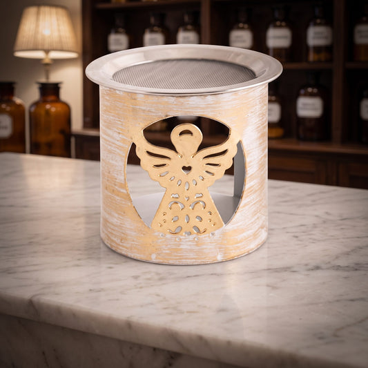 Siebgefäß Engel aus gold-weißem Metall mit ausgestanztem Engel auf der Marmortheke einer Apotheke am Abend