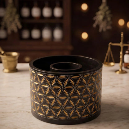 Smudge Bowl Blume des Lebens groß von Berk: schwarze Specksteinschale mit goldener Gravur auf der Marmortheke einer Apotheke am Abend