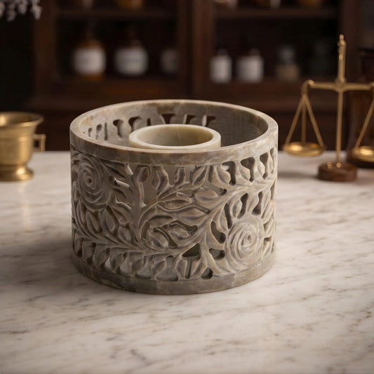 Smudge Bowl Yara groß von Berk: Schale aus Speckstein mit geschnitzten Rosenranken auf der Marmortheke einer Apotheke am Abend