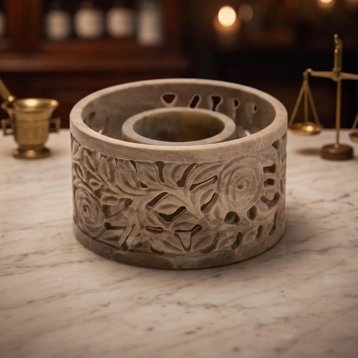 Smudge Bowl Yara klein von Berk: runde Schale aus Speckstein mit geschnitzten Rosenranken auf der Marmortheke einer Apotheke am Abend
