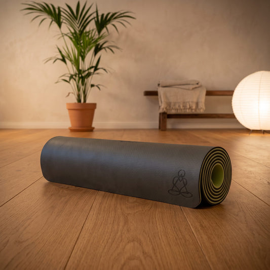 EcoBalance Yogamatte aus TPE, 182 × 61 cm, 6 mm, Baum des Lebens, dunkel/hellgrün: eingerollt auf dem Holzboden eines ruhigen Meditationsraums am Abend – Spirit of Gaia