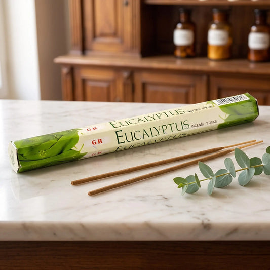 GR Eucalyptus Räucherstäbchen: Sechseck-Packung auf einer Marmortheke vor einem Apothekerschrank, daneben zwei lose Räucherstäbchen – Spirit of Gaia