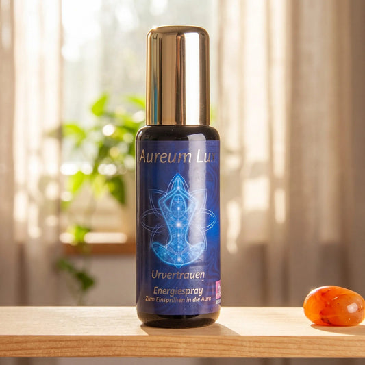 Energiespray Aureum Lux Urvertrauen: Sprühflasche auf einem hellen Holzregal am Fenster mit Leinenvorhang, daneben ein Karneol