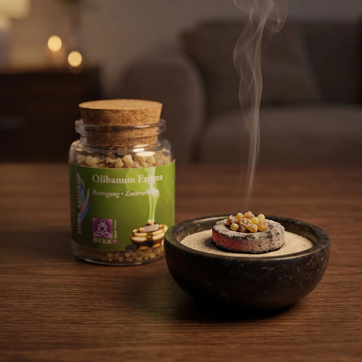 Olibanum Eritrea, reiner Weihrauch von Berk, 60 ml im Korkglas: einige kleine Weihrauchkörner glimmen auf der Räucherkohle, dahinter das Korkglas, feiner Rauch steigt auf einer dunklen Holzplatte am Abend auf – Spirit of Gaia