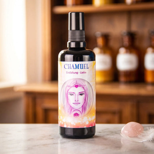 Seraphim Engel-Essenz Chamuel: Aura-Spray in dunkler Violettglasflasche auf Marmortheke vor Apothekerschrank, daneben ein Rosenquarz und eine weiße Feder – Spirit of Gaia