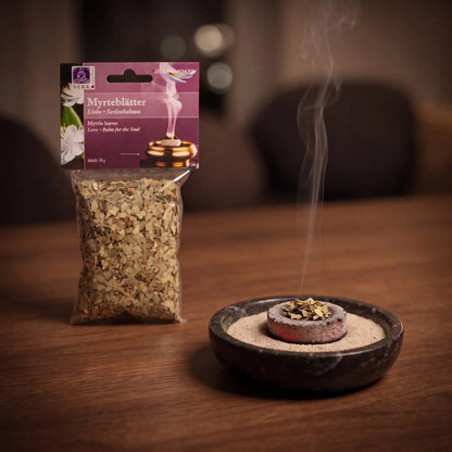 Myrteblätter, sortenreines Räucherwerk von Berk, 30 g: eine Prise Myrteblätter glimmt auf der Räucherkohle, dahinter die Tüte, feiner Rauch steigt auf einer dunklen Holzplatte am Abend auf – Spirit of Gaia