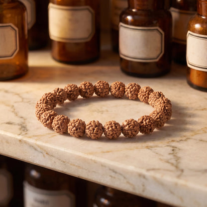 Rudraksha Armband von Berk auf einer Marmortheke vor braunen Glasflaschen