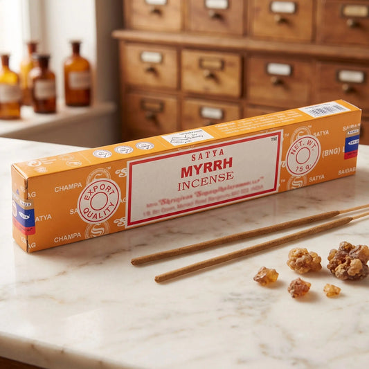 Satya Myrrh Räucherstäbchen: 15-g-Packung auf einer Marmortheke vor einem Apothekerschrank, daneben zwei lose Räucherstäbchen – Spirit of Gaia